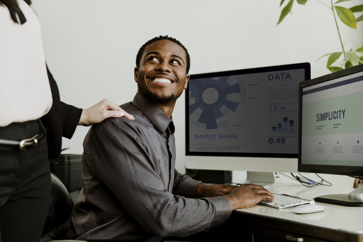 Happy black businessman working on a computer screen mockup