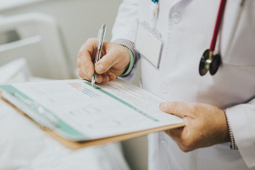 doctor writing notes on his note pad