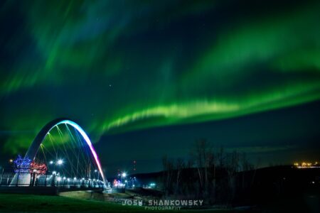 northern lights over a bridge in fort mcmurray