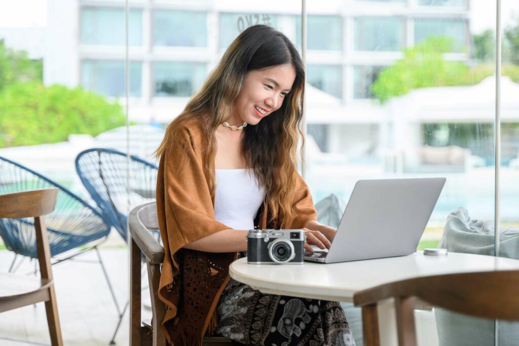 Smiling portrait of businesswoman working outdoor office, Asian woman using laptop at coffee shop, People with technology outside