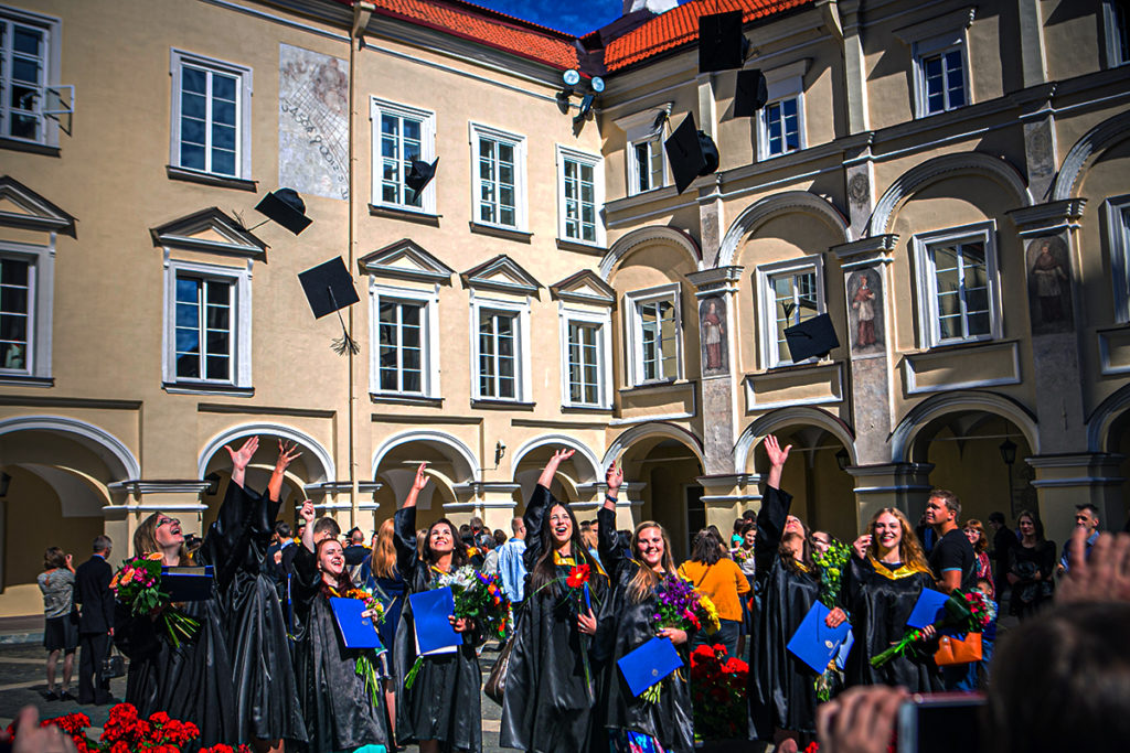 grads throw their hats in the air in vilnus university to celebrate